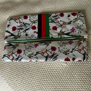 Clare V. Fold over clutch. Solid center stripes with flowers on white leather.